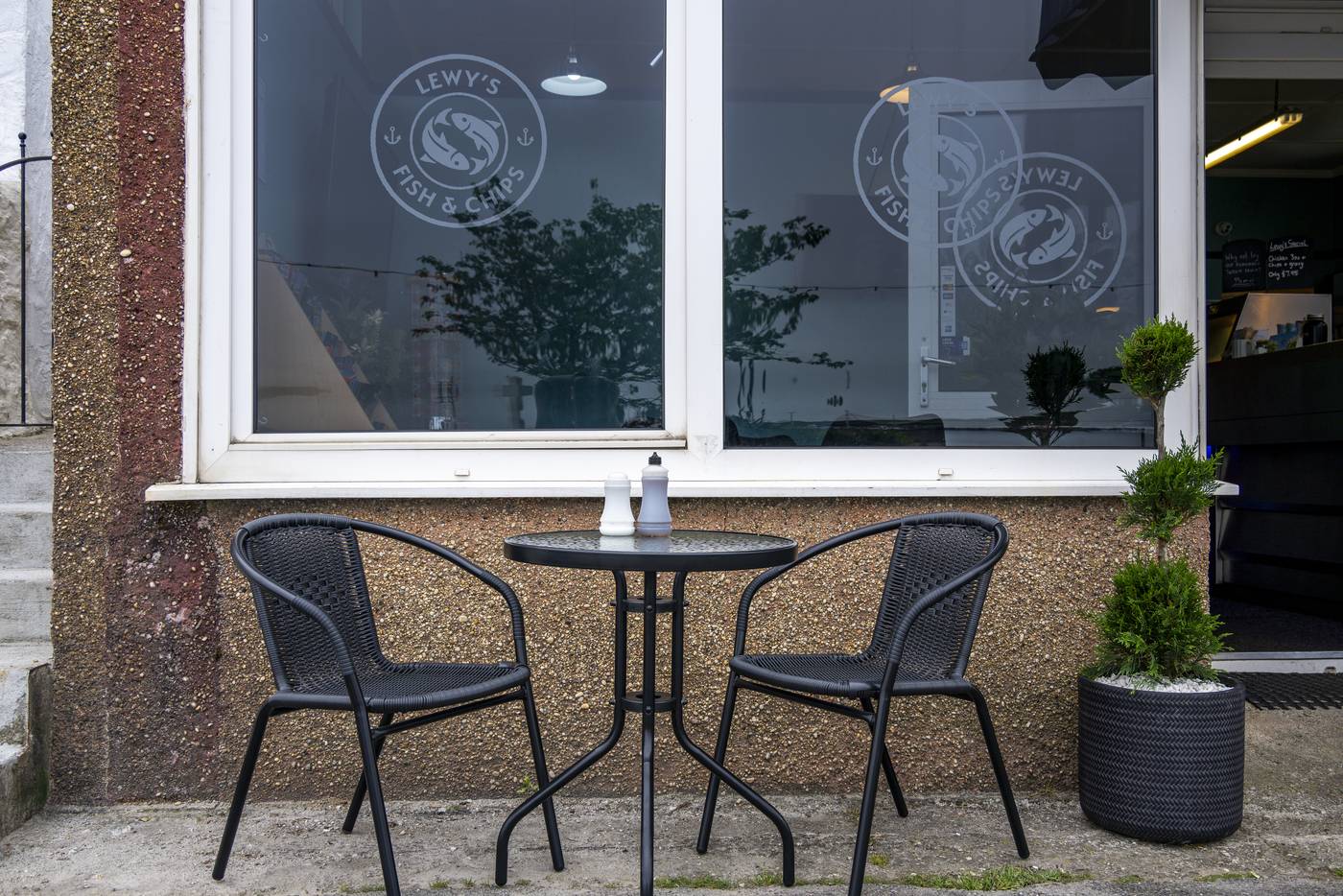 Outdoor seating at Lewy's with branded windows behind