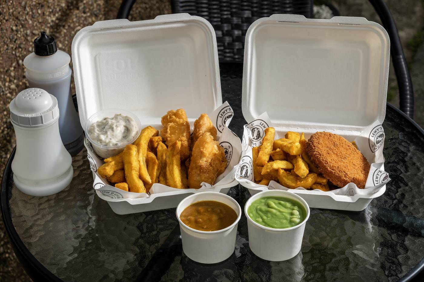 Two takeaway boxes from Lewy's with chips and sauces