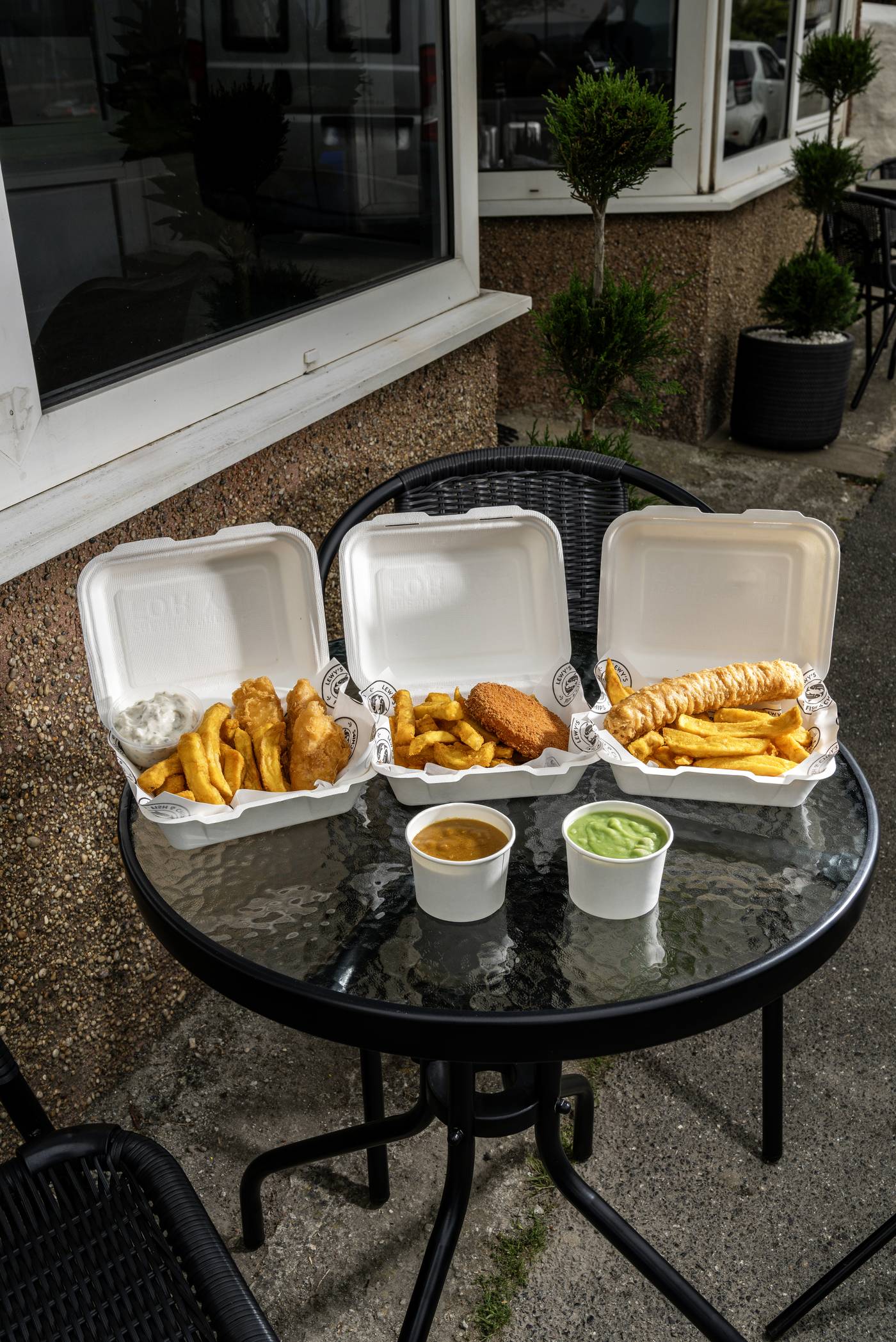Three takeaway boxes from Lewy's lined up on the outdoor table